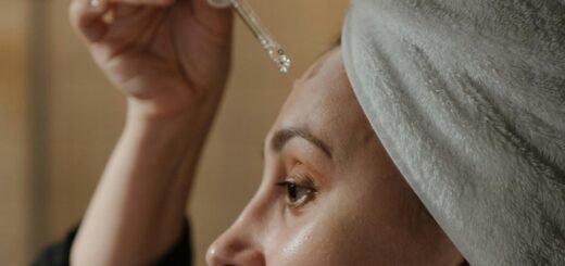 A woman applying a serum on their face.